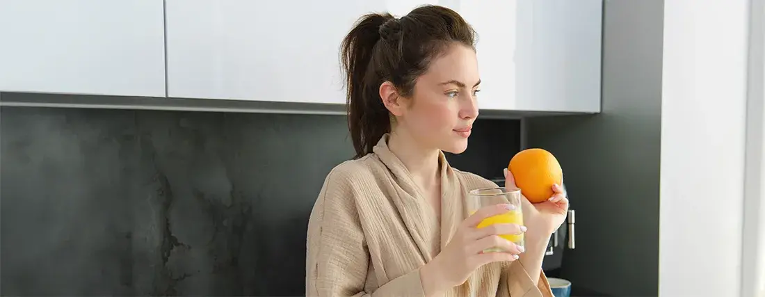 Mujer siguiendo una dieta antiinflamatoria con fruta y zumo natural, guiada por nutricionista antiinflamatorio en Elche.