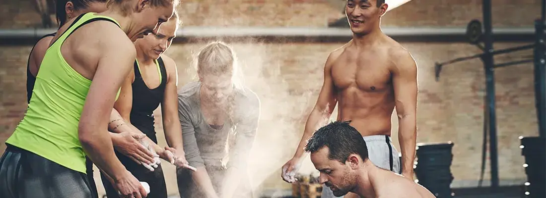 Deportistas preparando sus manos antes de entrenar en un box de crossfit, ejemplo de disciplina y necesidad de una nutrición deportiva personalizada