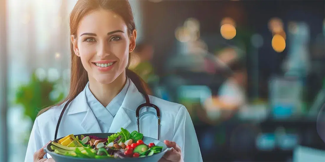Nutricionista vegana Alicante sosteniendo un plato de alimentos vegetales saludables